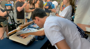 employee heat pressing a tote bag at the Miller Lite live print event activations